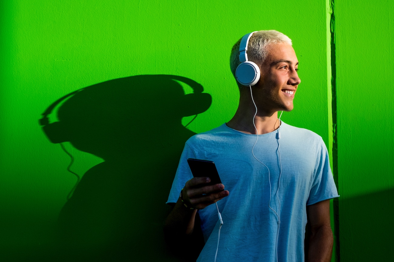 portrait of one teenager or young man listening to music using headphones millennial having fun hearing music